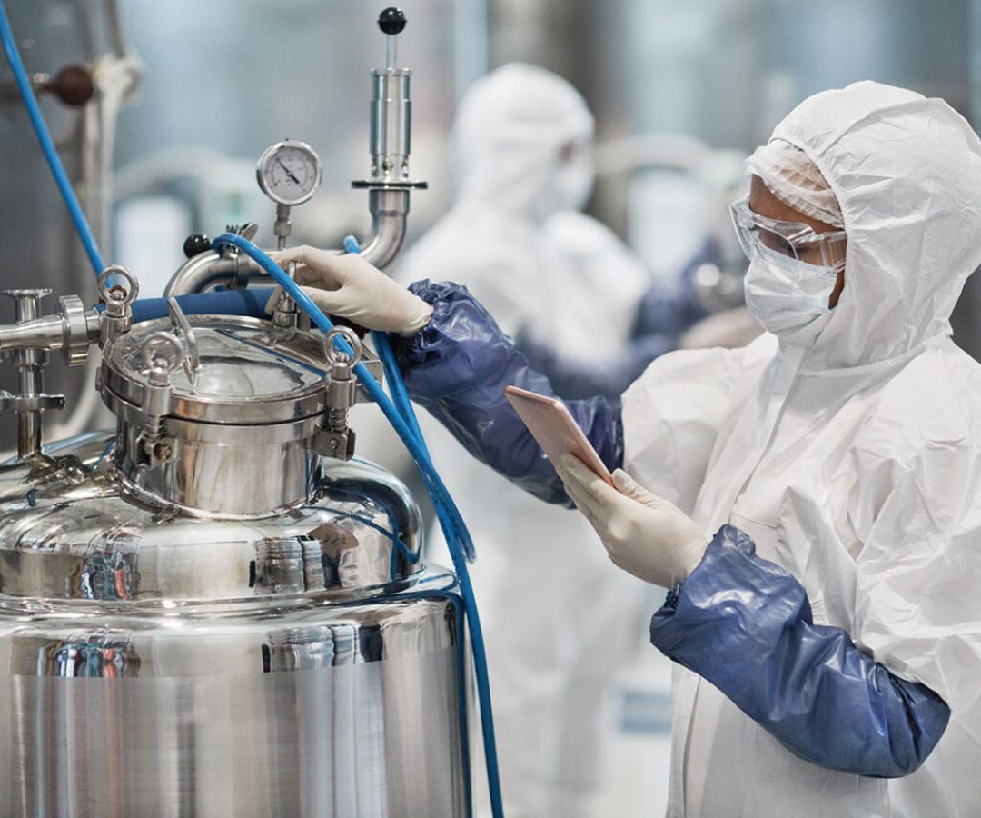 Portrait of female worker wearing protective suit while operating equipment at modern chemical plant, copy space